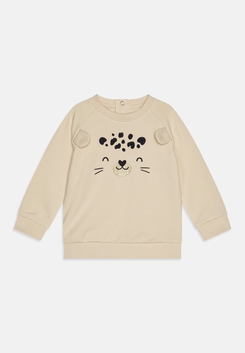 Sudadera beige con mangas largas, que presenta un diseño de cara de animal juguetona en negro y dorado. Tejido suave con bordes redondeados.