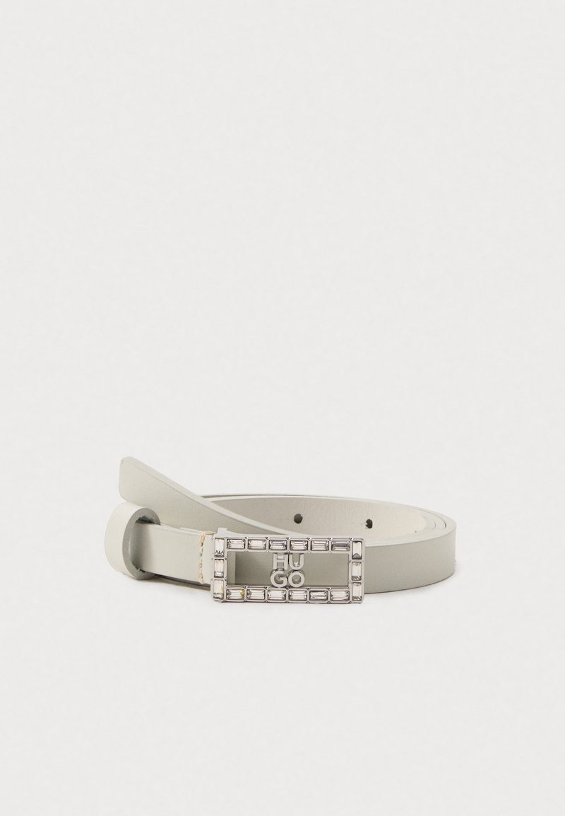 Cinturón de cuero gris claro con una hebilla rectangular de plata que presenta "HUGO" grabado, rodeado de acentos de resina clara. Textura suave, diseño minimalista.