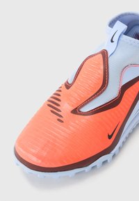 Svetlomodré a jasne oranžové športové topánky Nike na zips s textúrovanou prednou časťou, ťahacou slučkou a malými čiernymi logami swoosh.