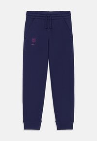 Jūras zila sporta bikses, kas izgatavotas no mīkstas auduma, ar elastīgu jostu, sānu kabatām un rozā Nike logotipu kopā ar Barselonas simbolu.