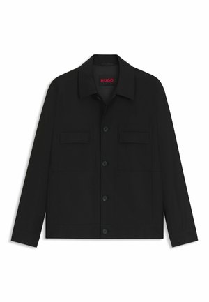 Black jacket featuring a button-up front, two chest pockets, and a collared neck. Made from smooth fabric with a structured design.