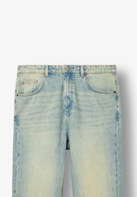 Világoskék farmernadrág, kopott hatással, gombos záródással, öt zsebbel és egyenes szárú kialakítással. Különböző méretekben elérhető.