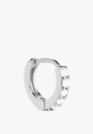 Srebrna kružna naušnica s poliranim završetkom i nizom prozirnih ukrasnih kamenčića duž jednog ruba.