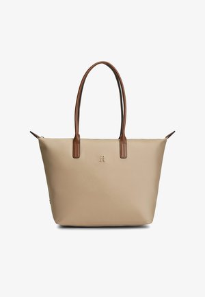 Beige Tragetasche mit langen braunen Griffen und kleinem Frontlogo, dargestellt auf weißem Hintergrund.