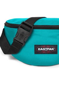 Marsupio Eastpak di colore teal realizzato in tessuto resistente, con una tracolla nera regolabile e una chiusura con zip, caratterizzato da un logo ben visibile.