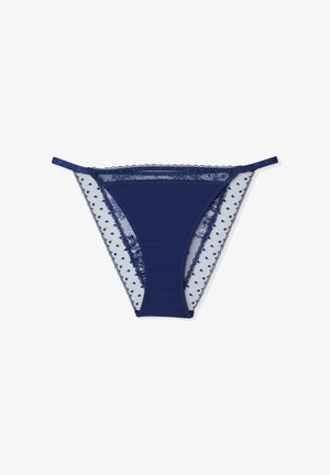 Navyblauer Tanga mit Spitzenbesatz, transparenten Punktenetz-Seiten und gezackten Rändern. Verstellbare Träger runden das Design ab.