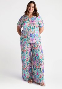 Conjunto de dos piezas con un patrón floral colorido que incluye una blusa de manga corta y pantalones de pierna ancha. El diseño abarca tonos de azul, rosa y verde.