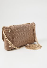 Brązowa kopertówka z koralikami o teksturowanej powierzchni, złotym łańcuszkowym paskiem i metalicznym zatrzaskiem. Prostokątny kształt, kompaktowy design oraz błyszczące akcenty.