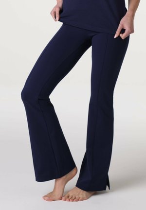 Pantaloni a zampa di elefante navy realizzati in materiale elasticizzato, con spacchi laterali all'orlo e design aderente. Texture liscia, con dettagli delle cuciture visibili.