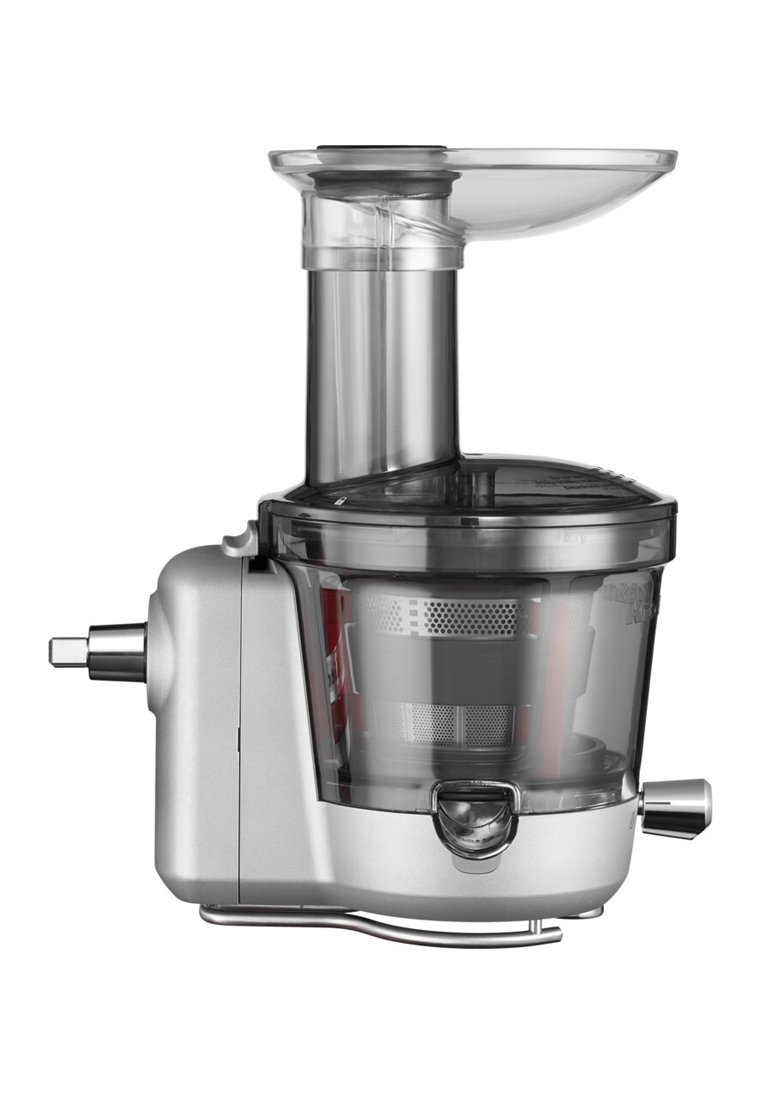 Extracteur de jus avec un boîtier en métal argenté, un récipient à jus en plastique transparent et un large tube d'alimentation. Il comprend un panier filtrant et un bec verseur.