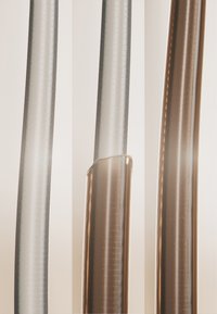 Tre närbild på tunna, rörformade objekt med en slät, reflekterande yta i klara och bronsfärger, med subtila texturer.