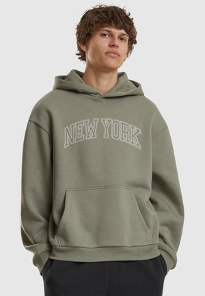 Olive green hoodie with "NEW YORK" text in white arch design. Features a front pocket and drawstring hood. Cotton blend fabric.