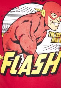 Red cotton t-shirt featuring a comic-style graphic of The Flash, showcasing muscular character design and bold yellow text.