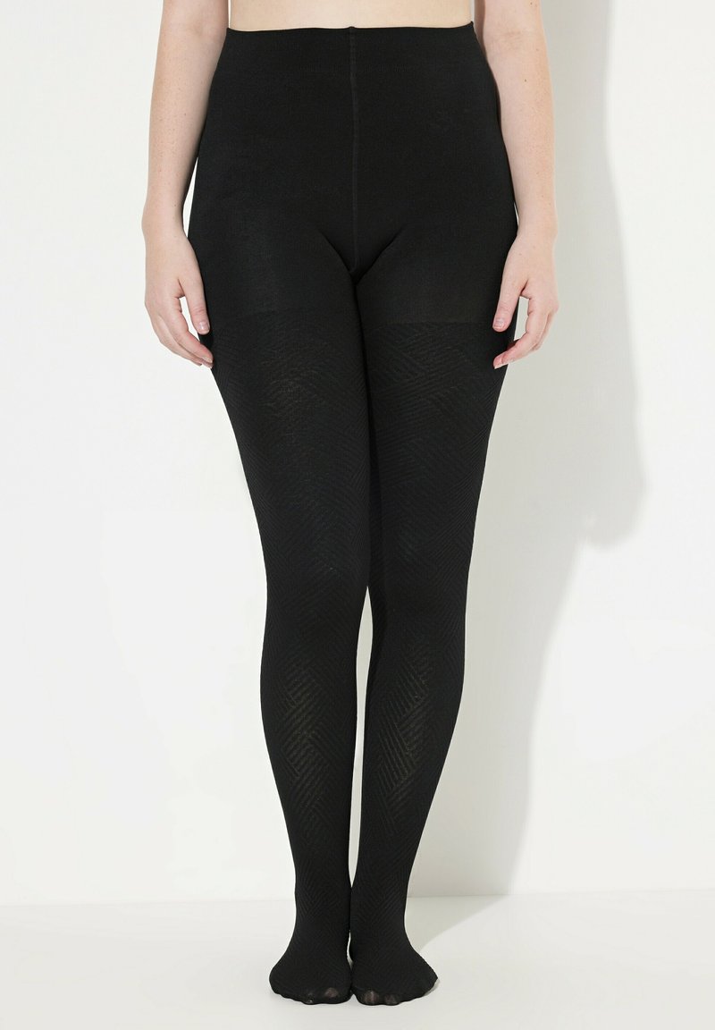 Collants noirs avec une taille haute, présentant un motif en chevrons texturé et une zone de renfort au niveau des orteils. Matériau opaque et doux.
