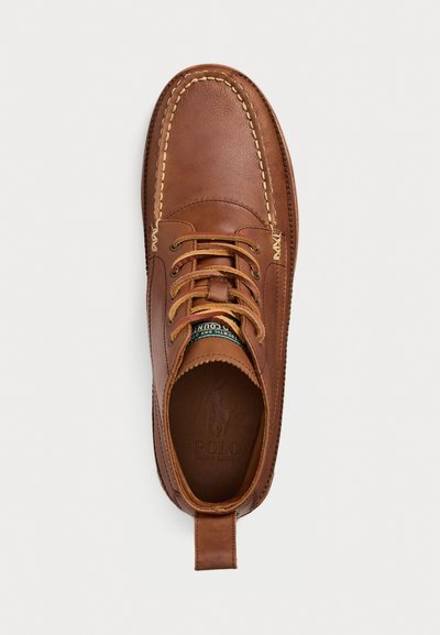 Brune lær snørestøvler med beige sømmer og preget Polo Ralph Lauren-logo på innsiden av sålen.