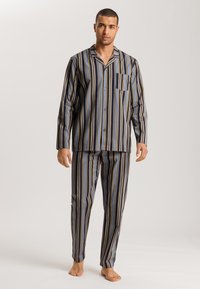 Conjunto de pijama a rayas en azul, amarillo y marino. Presenta mangas largas, una camisa de botones con un bolsillo en el pecho y pantalones de pierna recta.
