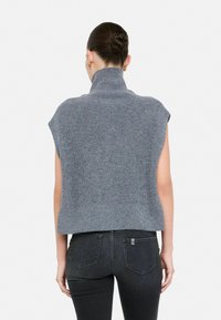 Maglione grigio lavorato a maglia con colletto alto, maniche corte e silhouette corta. Presenta una texture a coste e un colore uniforme.