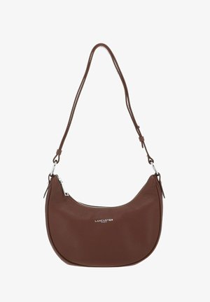 Sac à bandoulière en cuir marron avec une forme courbée, fermeture éclair argentée et bretelles réglables ; présente un logo en relief à l'avant et une surface texturée.