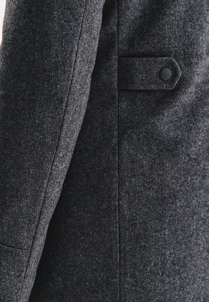 Czarny grafitowy płaszcz w jodełkę z wełny o slim fit, z zapinaniem na jeden guzik i boczną kieszenią. Teksturowany materiał z wyrafinowanym wzorem.