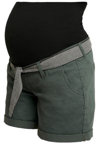 Graviditetsshorts i mörkgrön tyg med en rullad fåll och ett kontrasterande bälte i svart och vitt i fiskbensmönster knutet i midjan.