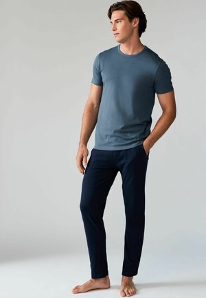 Blaues Kurzarm-T-Shirt und dunkelblaue Hose, beide aus weichem Stoff. Das T-Shirt hat einen runden Halsausschnitt, die Hose sitzt eng und hat einen elastischen Bund.