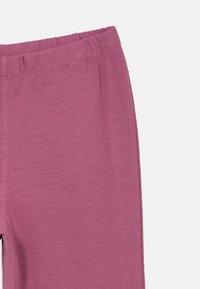 Paarse katoenen leggings met een elastische tailleband. Naaddetails en een zachte textuur zijn opvallend aanwezig. Geen extra patronen of accenten.