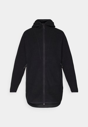 Veste en polaire noire avec fermeture éclair à l'avant, capuche et poches latérales. Présente une surface texturée et un ourlet courbé pour un ajustement décontracté.