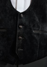 Gilet di velluto nero con scollatura a V, cinque bottoni rotondi, tasche laterali e dettagli di cucitura discreti.