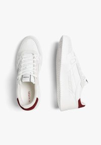 White sneakers with a mix of smooth and textured materials, featuring maroon accents at the heels and a patterned rubber sole.