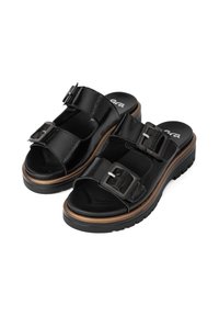 Black patent leather sandals with two adjustable buckle straps, a cushioned footbed, and a thick rubber sole featuring a wood accent.