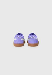 Paarse suède sneakers met een lichtgrijze accent, bruine rubberen zool en een klein goudkleurig logo aan de achterkant. Ronde hak en gevoerde kraag.