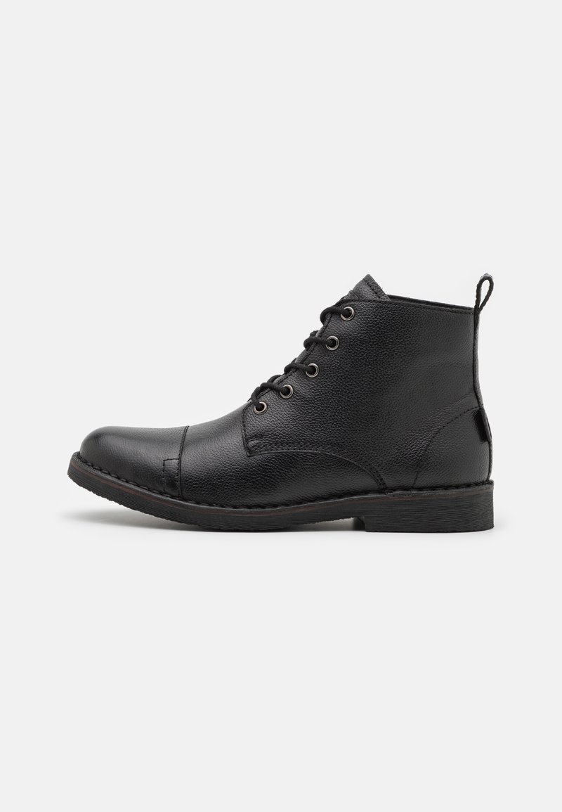Bottine en cuir noir avec lacets à l'avant, bout arrondi et languette à l'arrière, vue de profil sur fond blanc.