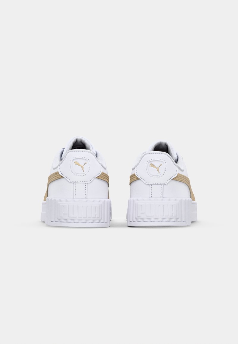 Baskets blanches avec des accents beiges, semelle texturée, col rembourré et un logo doré sur le talon. Lacets plats et design de bout arrondi.