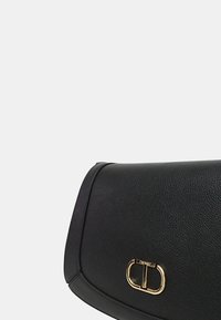 Borsa a tracolla nera in pelle con una forma strutturata, caratterizzata da un accento del logo in tono oro e una finitura testurizzata. Design elegante e minimalista.