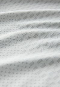 Textured fabric in light grey, featuring a subtle grid pattern with small squares and dots, creating a smooth, woven appearance.
