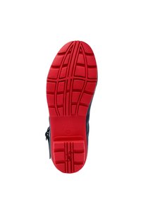 Suola di una scarpa con una suola in gomma rossa dotata di un motivo di grip testurizzato, bordata da un materiale superiore di colore blu scuro. Logo del marchio presente.