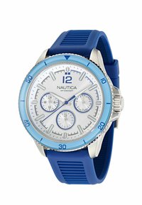 Reloj Nautica con correa de goma azul, caja de acero inoxidable plateado y bisel azul claro. La esfera blanca presenta acentos azules y subdiales.