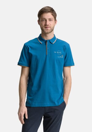 Teal polo shirt gemaakt van katoen met oranje accenten op de kraag en mouwen. Bevat geborduurde tekst op de borst met een klassieke pasvorm.