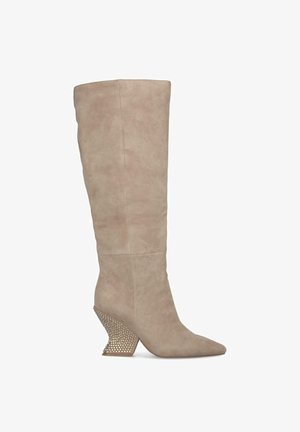 Bottes en suède beige jusqu'aux genoux avec un bout pointu et un talon compensé décoratif en perles pour un détail supplémentaire. Texture lisse sur l'ensemble.