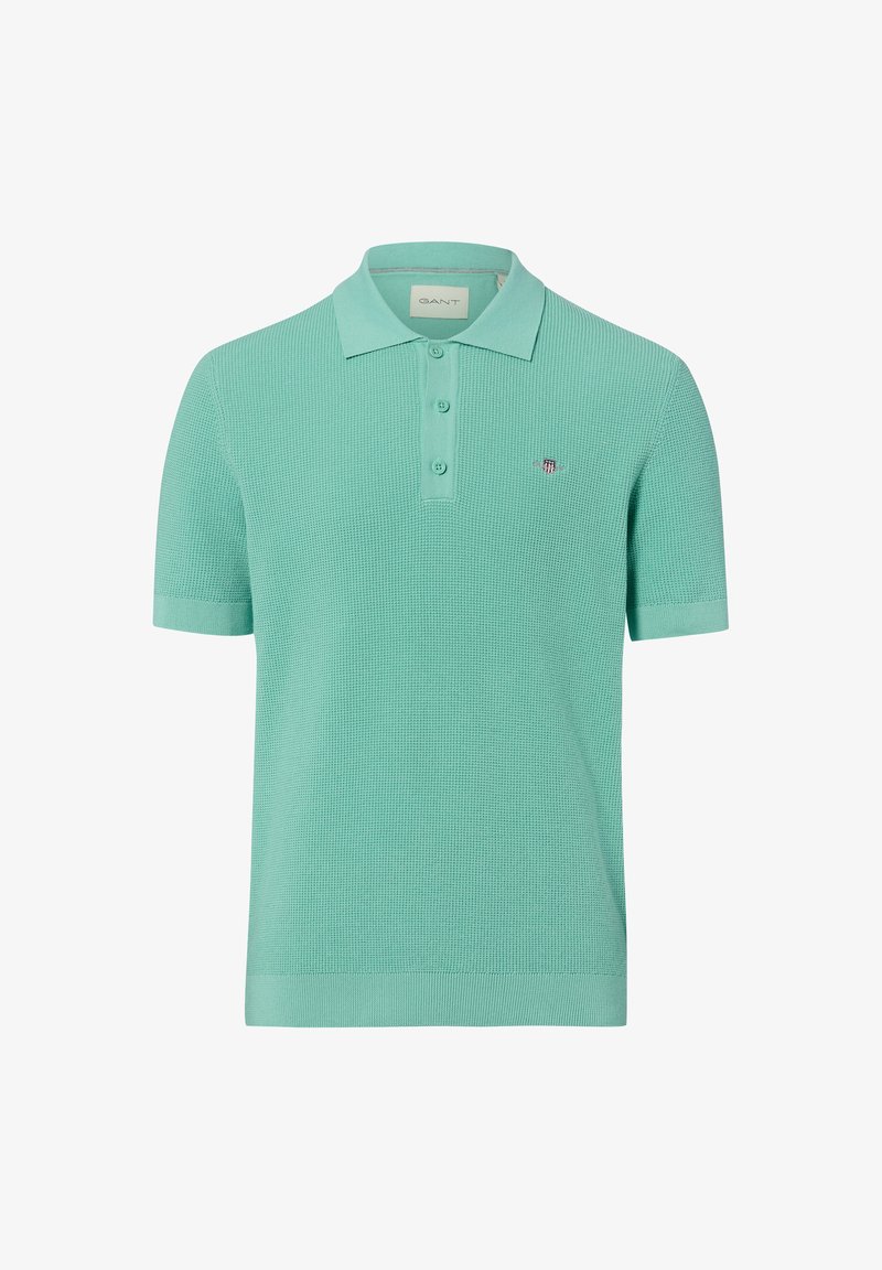 Polo vert menthe à manches courtes en maille texturée, à patte à trois boutons et petit logo brodé sur la poitrine.