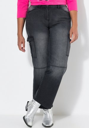 Pantalons cargo gris foncé avec poches latérales et une coupe décontractée, associés à des bottes cheville argentées brillantes. Texture en denim lisse.
