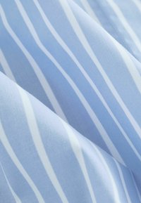 Tissu bleu clair avec des rayures verticales blanches, texture lisse et éclat subtil, mettant en valeur un motif rayé classique.