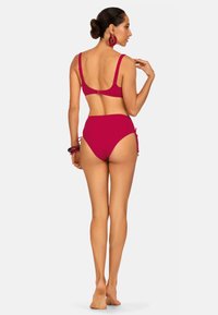 Fuksjowy zestaw bikini z zapięciem na hak, regulowanymi ramiączkami, wysokim stanem majtek oraz bocznymi trokami dla dostosowania do indywidualnych potrzeb.