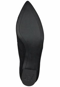 Černý semišový bot s špičatou špičkou a hladkou černou gumovou podrážkou; obsahuje vyražené logo na patě a elegantní, štíhlý design.