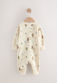 Grenouillère pour bébé couleur crème avec une texture douce, présentant un motif fantaisiste d'animaux et d'arbres, des poignets côtelés et un col arrondi.