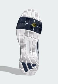 Sole obuvi s bílým základem, námořnickými akcenty a texturovanými grip vzory. Obsahuje kruhový žlutý detail a prodlouženou část paty.