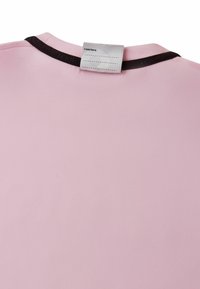 Różowy garment z czarnym paskiem kołnierza i białą etykietą z napisem "Byłem tu:" oraz pustymi liniami do pisania.