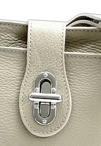 Grau strukturiertes Lederhandtaschenverschluss mit einem glänzenden silbernen Metallverschluss und auffälligen Steppdetails.