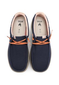 Des chaussures en toile navy avec des lacets oranges, des semelles beige texturées et une doublure à motif zigzag. Étiquette de marque "PITAS" visible à l'intérieur.