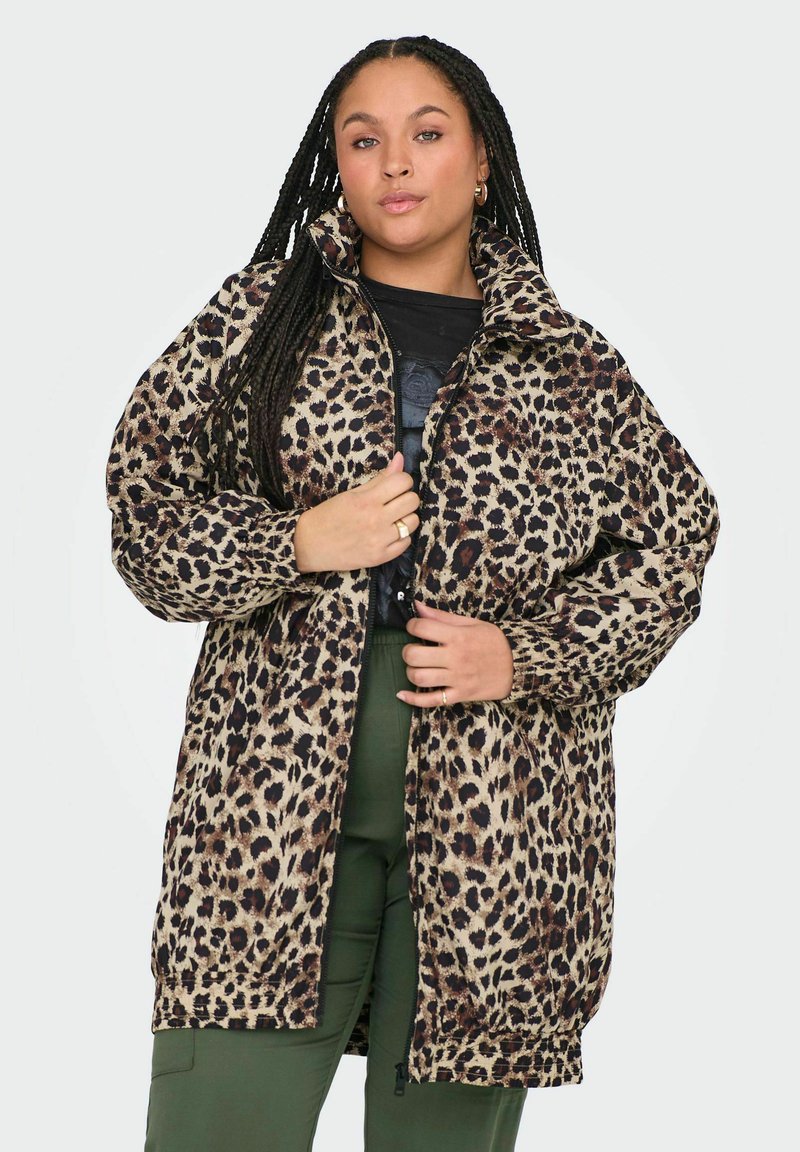 Jakna s leopard uzorkom, visokim ovratnikom, dugim rukavima i zatvaranjem na zip. Meka, teksturirana tkanina s crnim i smeškim mrljama na bež pozadini.